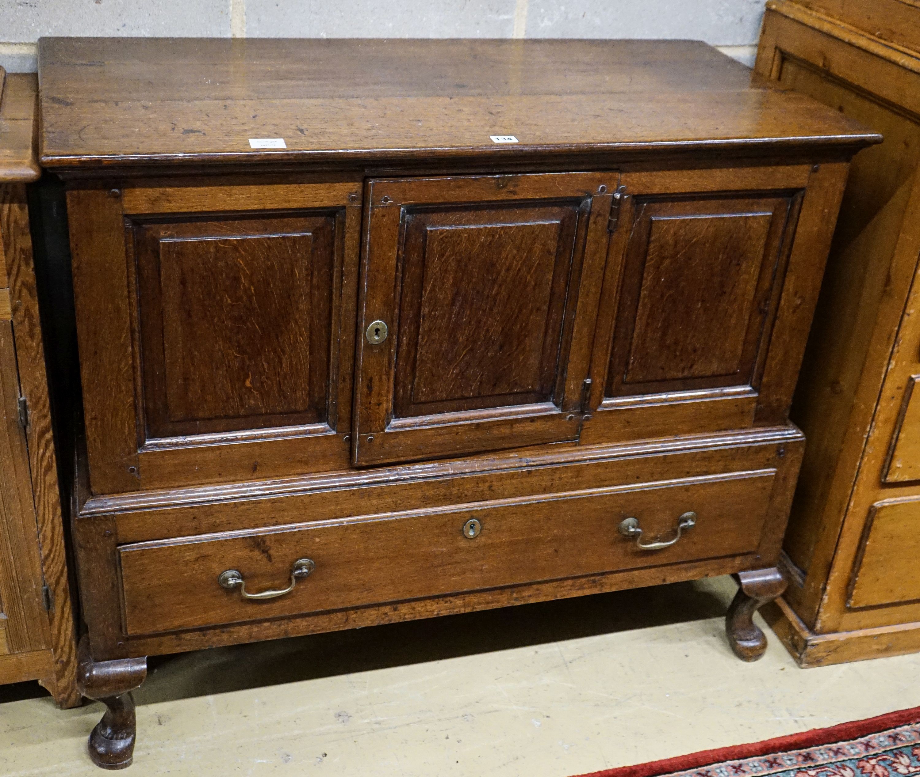 A mid 18th century oak mule chest, with later converted central door and later stand with cabriole legs, width 109cm, depth 53cm, height 93cm